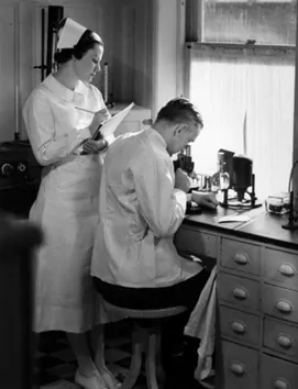 black and white image of nurse behind a doctor